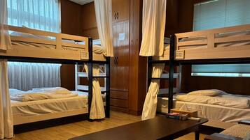 Un dormitorio con literas, paredes de madera y cortinas.