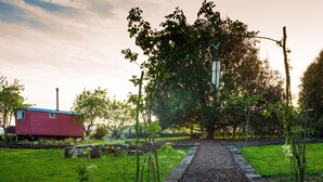 A rural landscape with a red house, a tree-lined path, and a grassy area. - Samsara Retreat and Yoga - Adults Only (Maidstone)