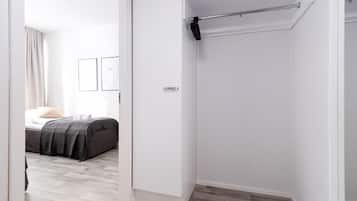 A bedroom with a bed, a wardrobe, and a bathroom with a towel rack.