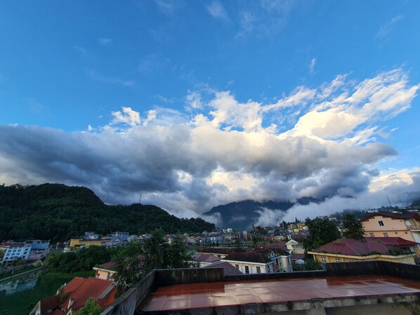A view of a town with buildings and a mountain in the background.