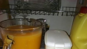 Keittiön työtasolla on suuri kannu appelsiinimehua, tehosekoitin ja kaksi kulhoa hedelmäsalaattia.