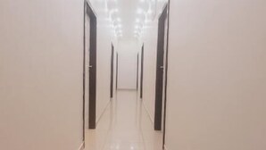 A long, narrow hallway with doors on both sides and a shiny tiled floor. - Bayside Lodge Empangeni (Empangeni)