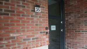 A brick building with a numbered door, a keypad lock, and a glass door. - Forenom Serviced Apartments Rovaniemi (Rovaniemi)