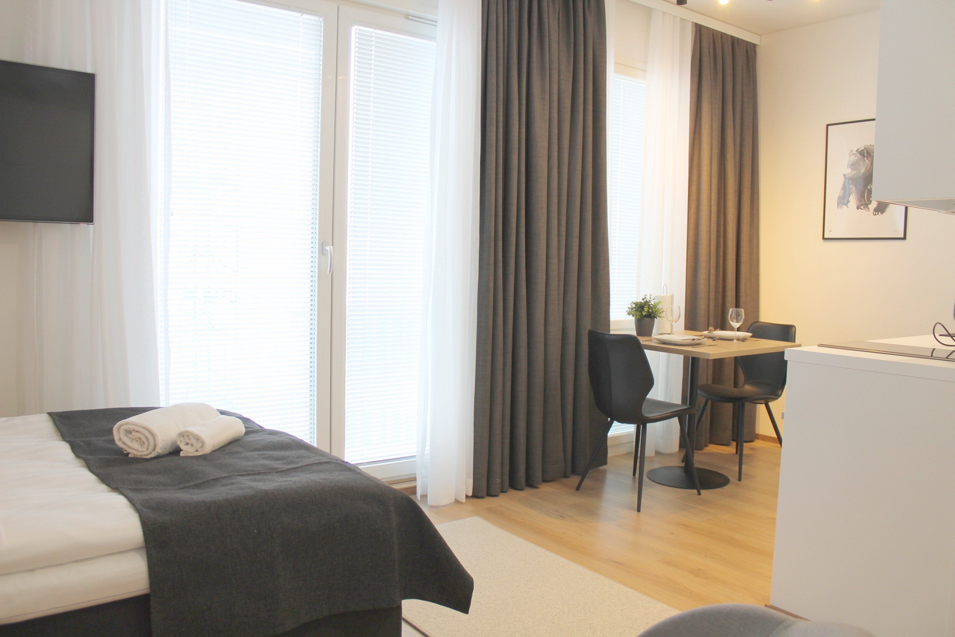 A hotel room with a bed, a desk, and a chair.