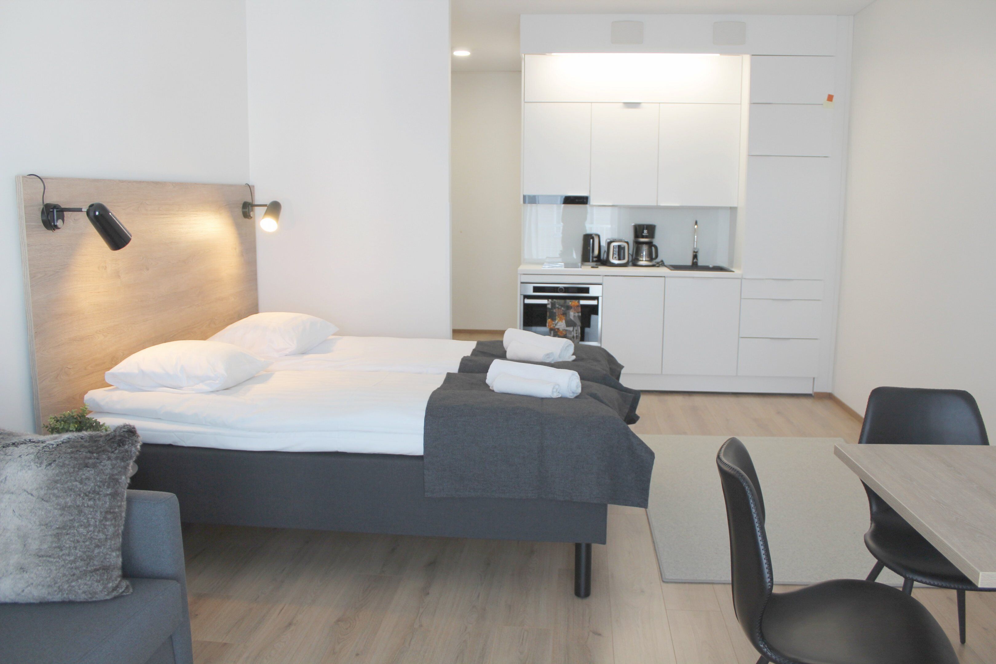 Une chambre d’hôtel moderne équipée d’un lit, d’un bureau et d’une kitchenette.