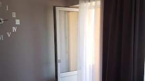 Una habitación con cama, una mesa, un espejo y una puerta.