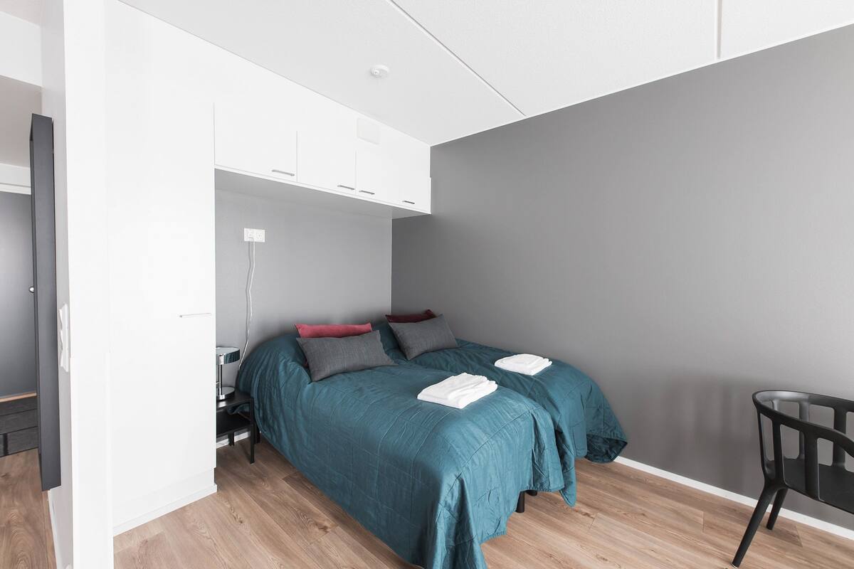 Une chambre à coucher moderne avec un lit, des tables de chevet et une chaise.