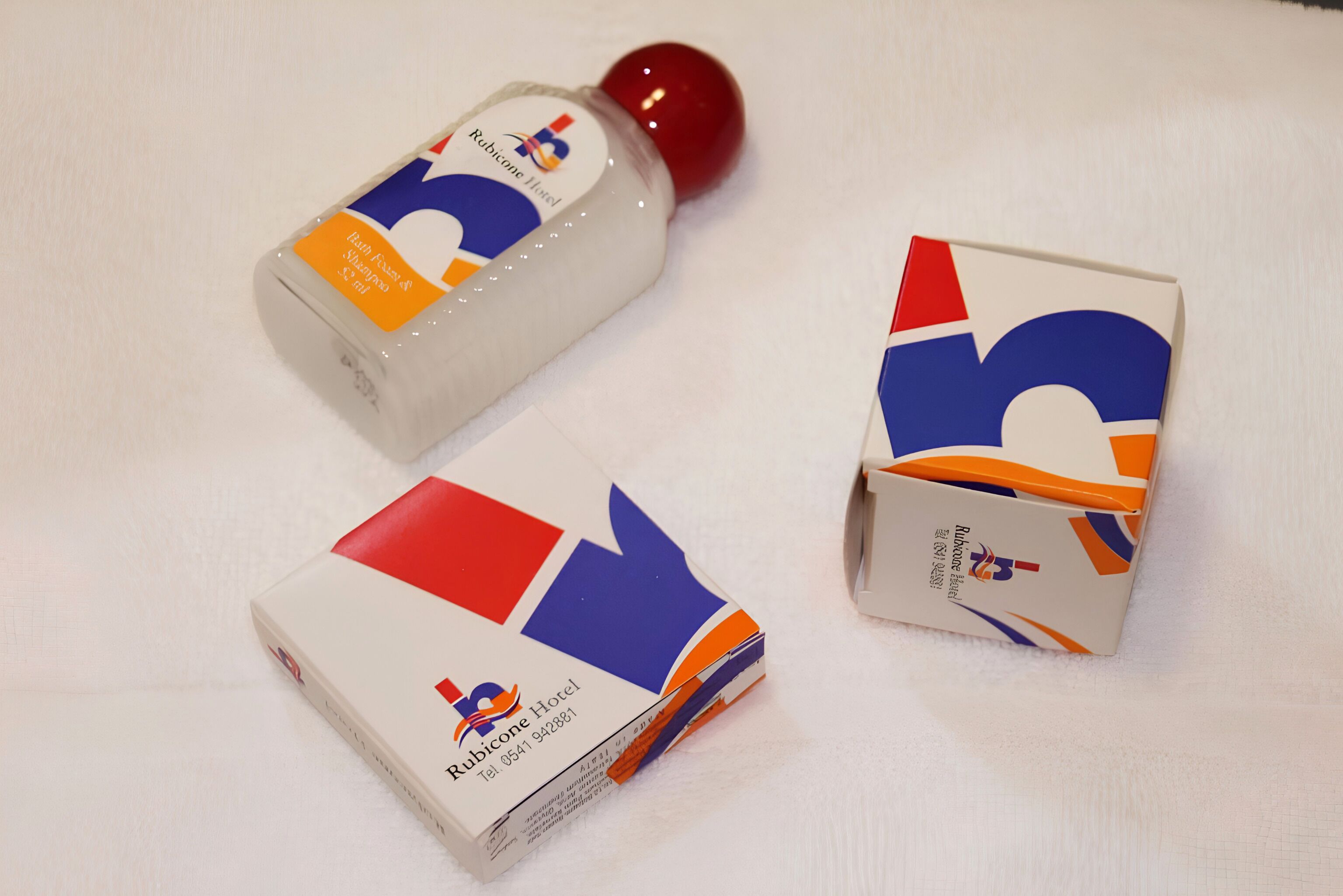 Une bouteille de savon liquide et deux boîtes de produits d’accueil pour les hôtels.