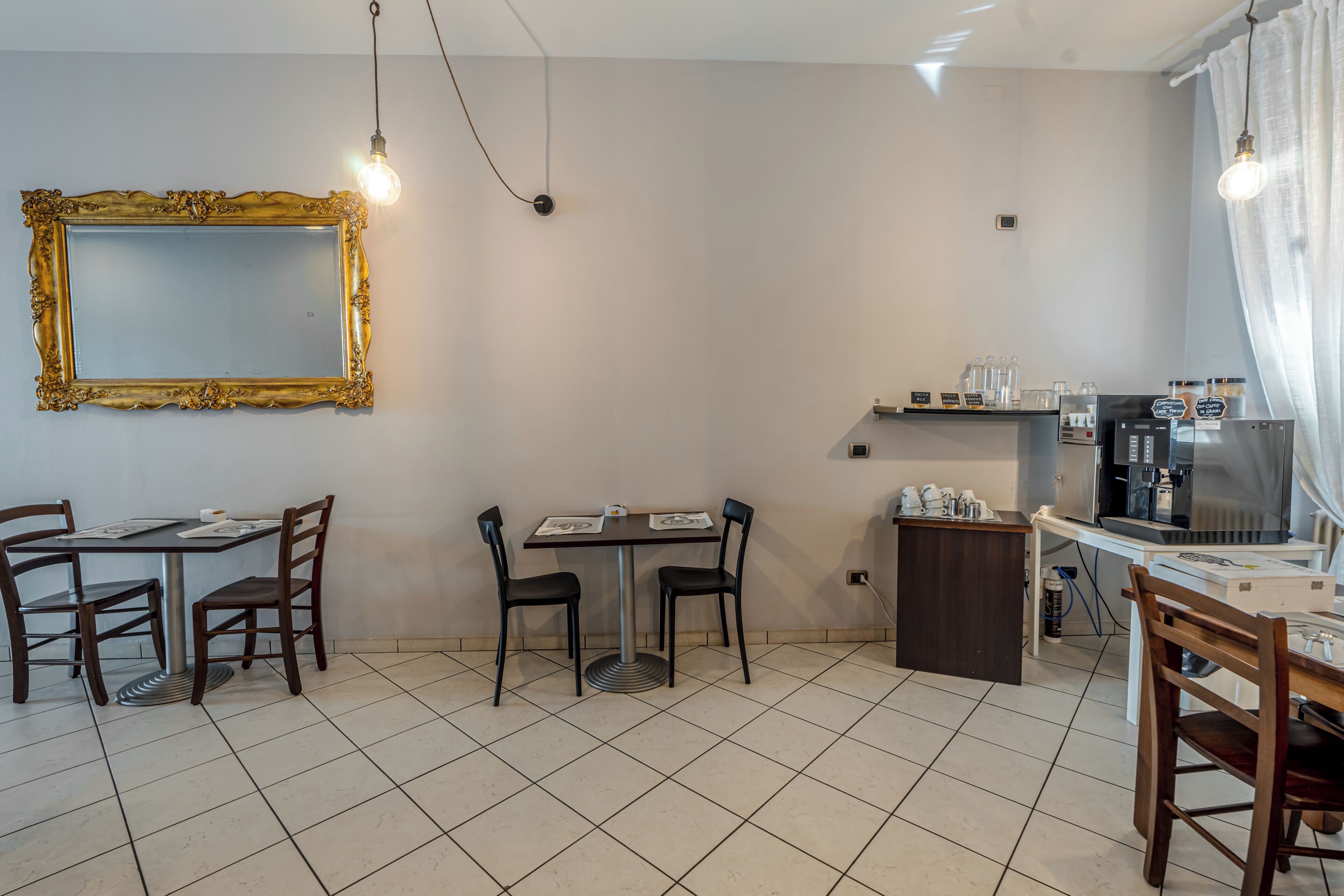 Een eetgedeelte met een tafel, stoelen, een spiegel en een koffiehoek.