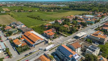 Zona residencial con casas, una calle principal y un edificio grande con paneles solares.