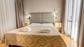 A neatly made bed with a floral bedspread, two bedside lamps, and a headboard.