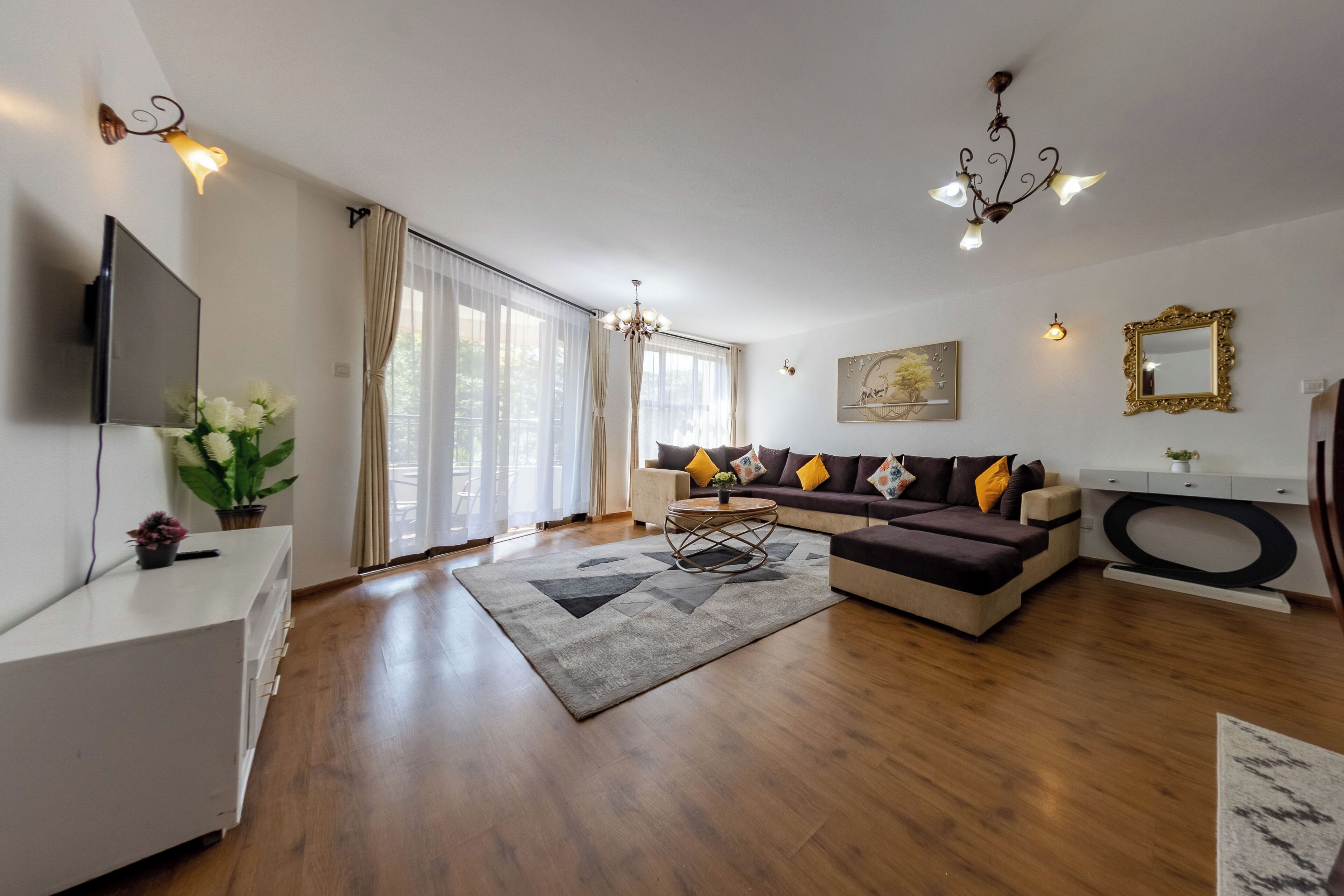 A modern living room with a sofa, TV, and decorative items.