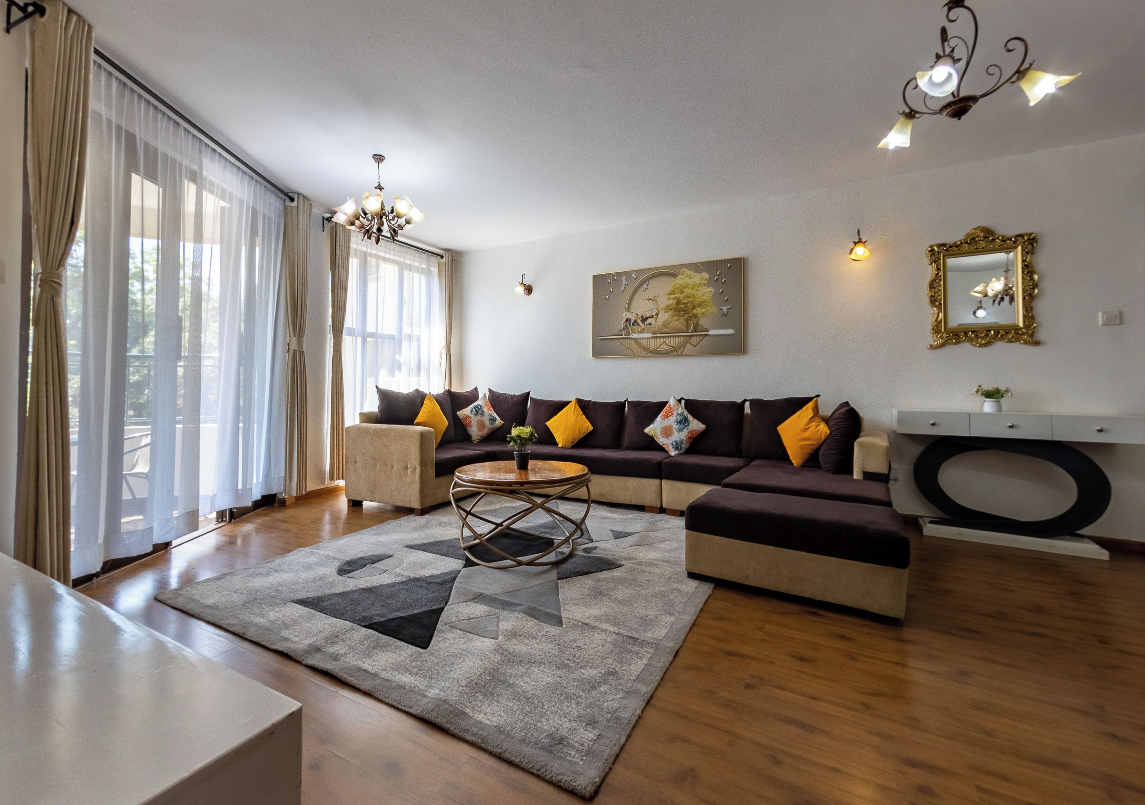 A living room with a sofa, a coffee table, and a chandelier.