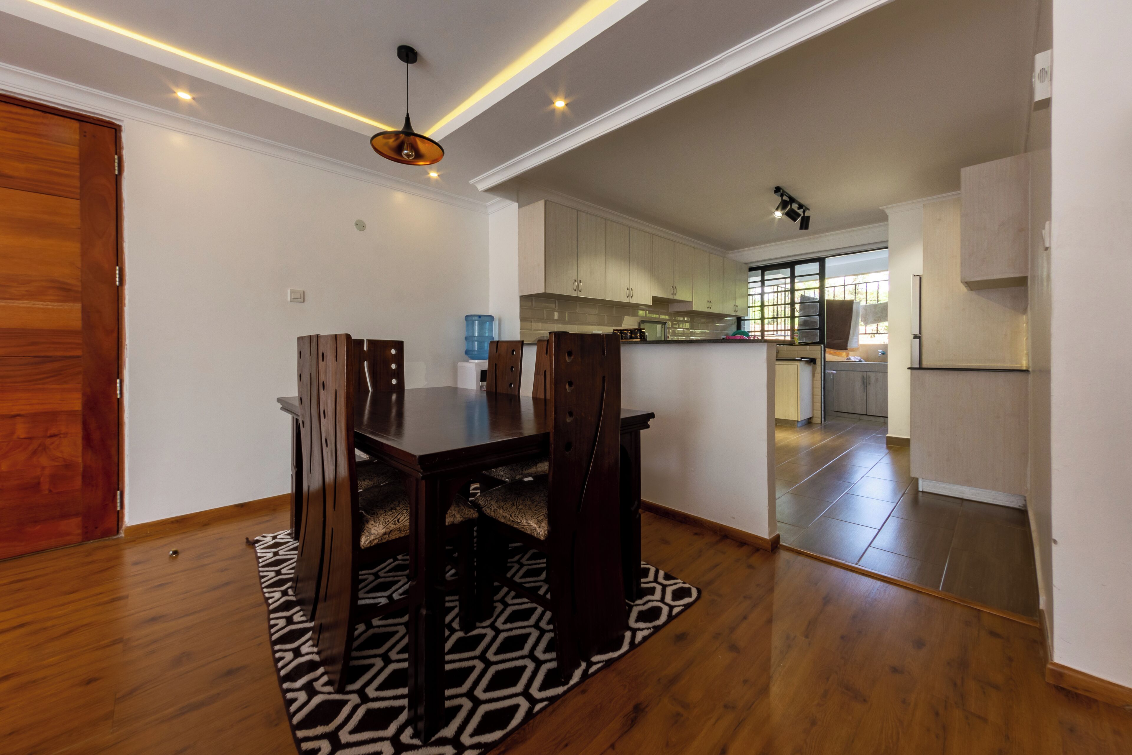 Una cocina moderna con armarios blancos, horno integrado y una isla grande.