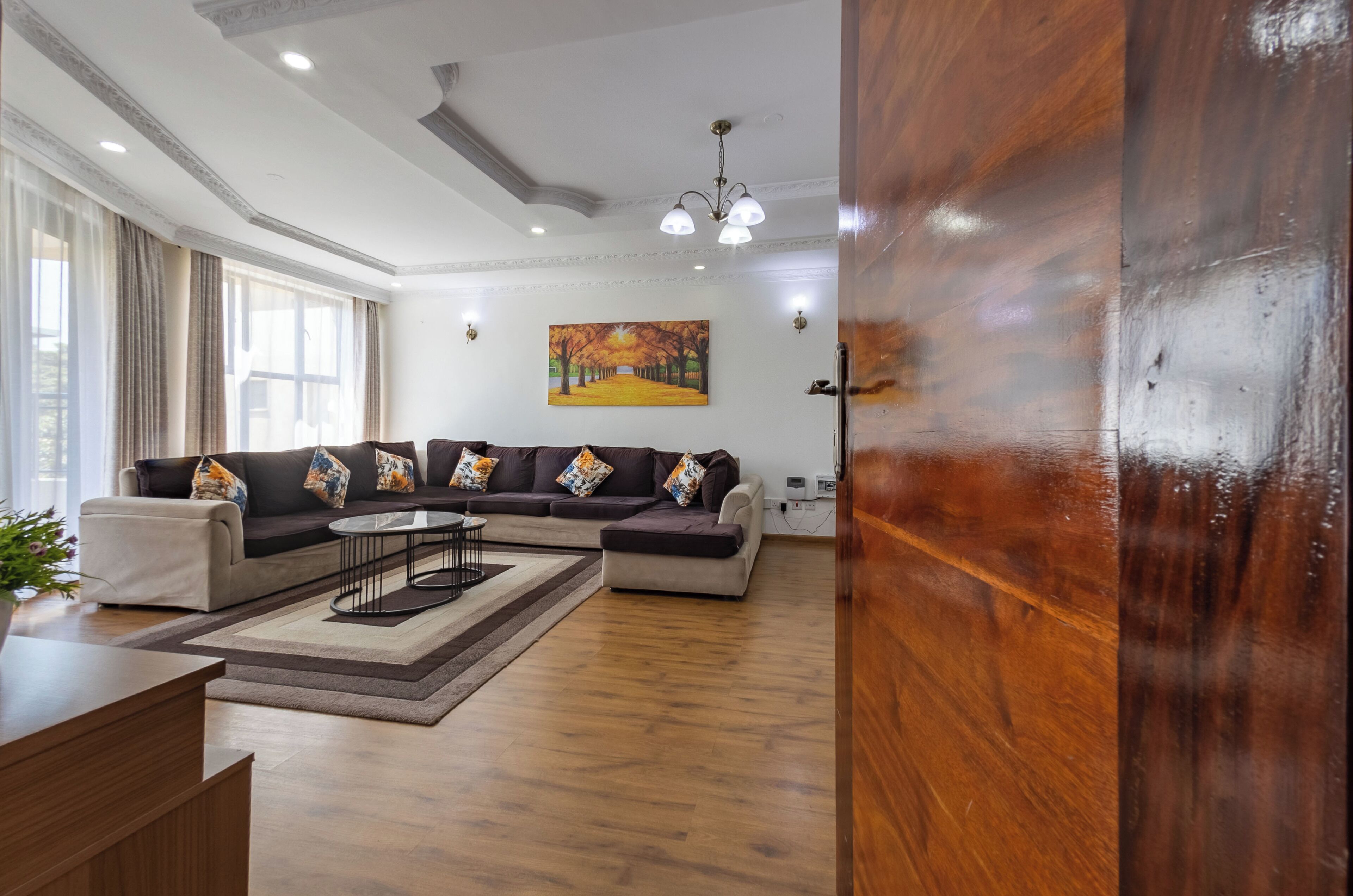 Una sala de estar moderna con un sofá modular, una mesa de centro y un mostrador de recepción de madera.