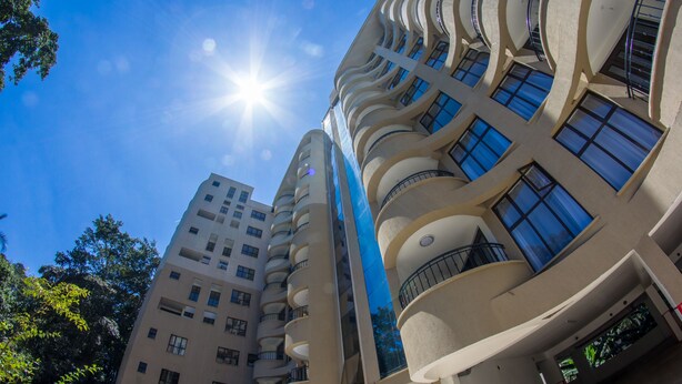 A multi-story building with a curved facade, large windows, and balconies. - Erica Residences (Nairobi)