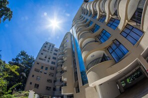 Un immeuble à plusieurs étages doté d’une façade incurvée, de grandes fenêtres et de balcons.