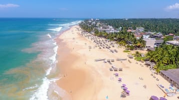 On the beach, white sand, sun-loungers, beach umbrellas