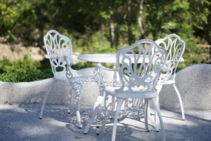 A white metal outdoor table and chairs set on a concrete surface with a natural backdrop. - Hemerocallis Country House (Nanzhuang)