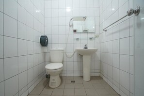 A small, clean bathroom with white tiles, a toilet, a sink, a hand dryer, and a mirror. - Hemerocallis Country House (Nanzhuang)