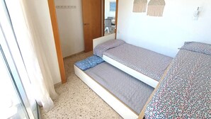 Una camera da letto con un letto, un tavolino, una sedia, uno specchio e una finestra.