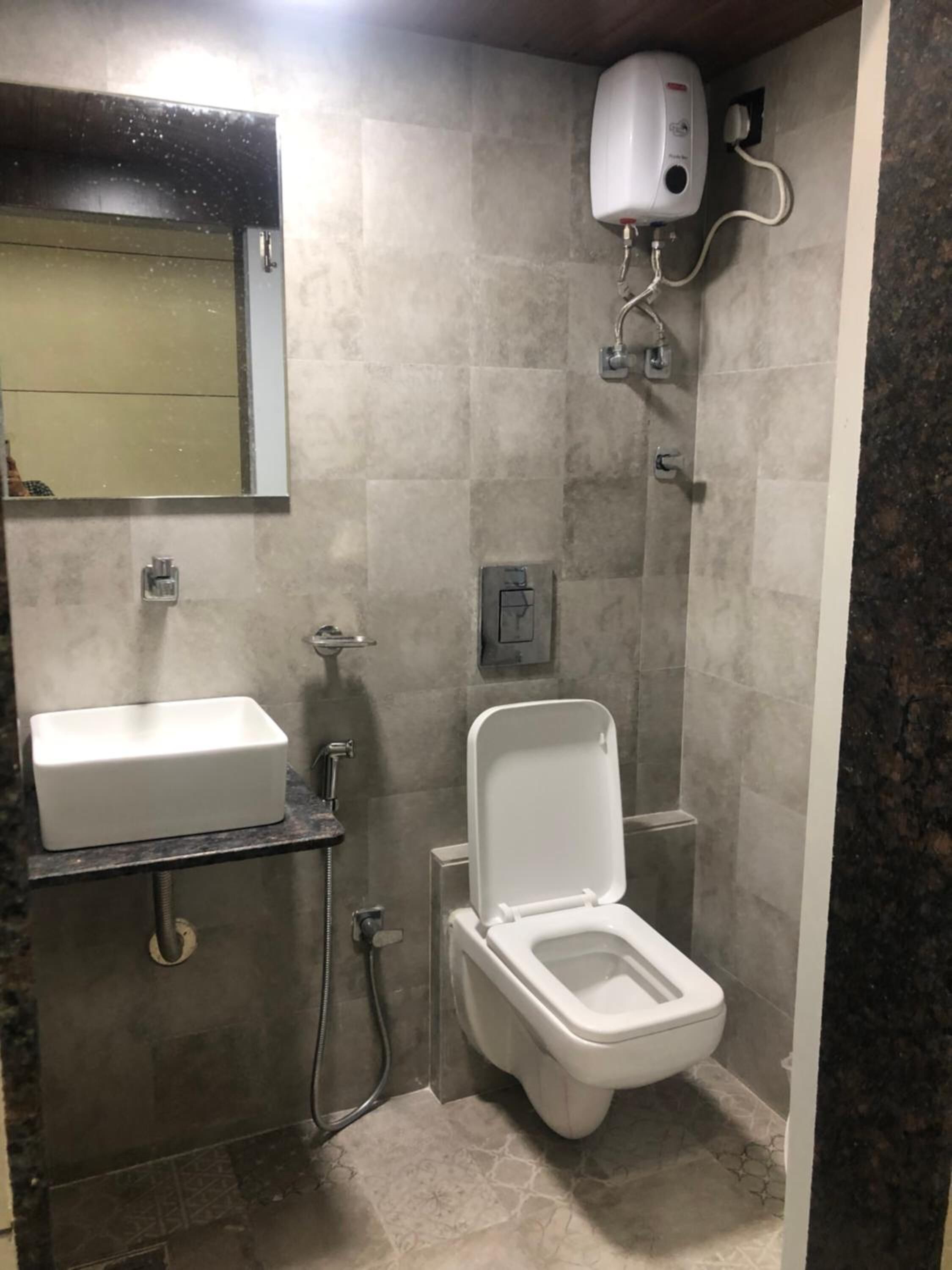 A bathroom with a toilet, sink, and shower.