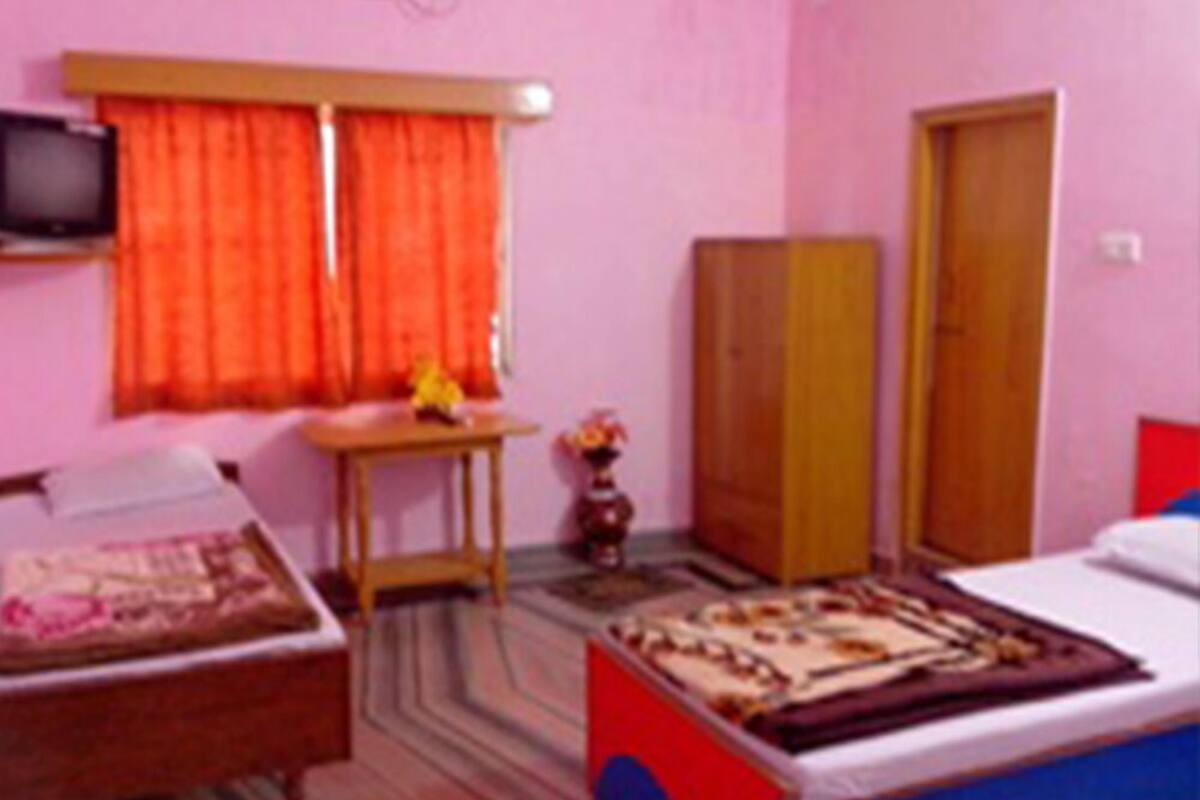 Una habitación con cama, escritorio, armario y televisor.