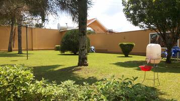 Enjoy the serene outdoor space with a lawn, trees, and a water dispenser for your convenience.