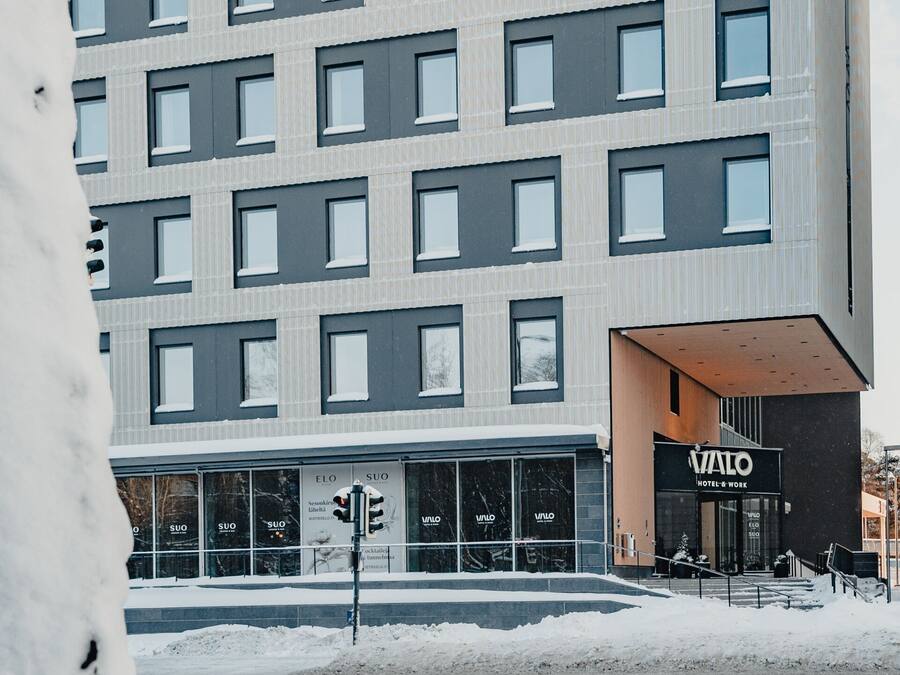 A modern hotel building with multiple floors and large windows.
