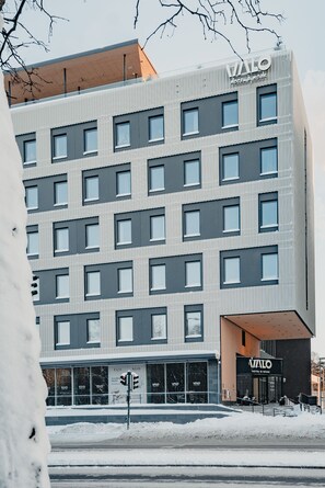 Een modern hotelgebouw met meerdere verdiepingen en grote ramen.