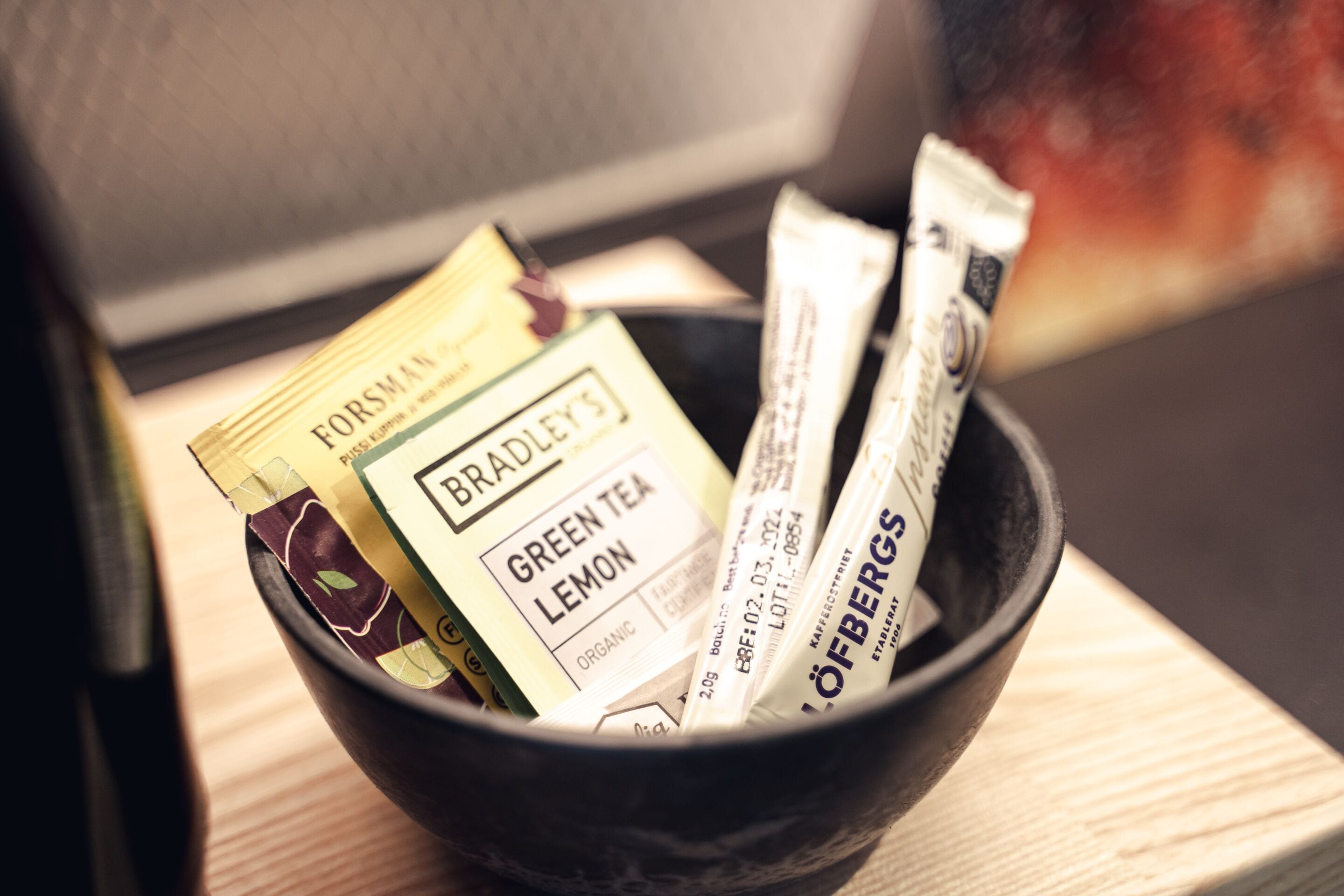 A black bowl containing various tea packets.