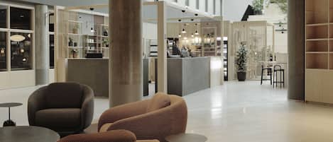 Un vestíbulo moderno con zonas de estar, un mostrador de recepción y vistas del interior.