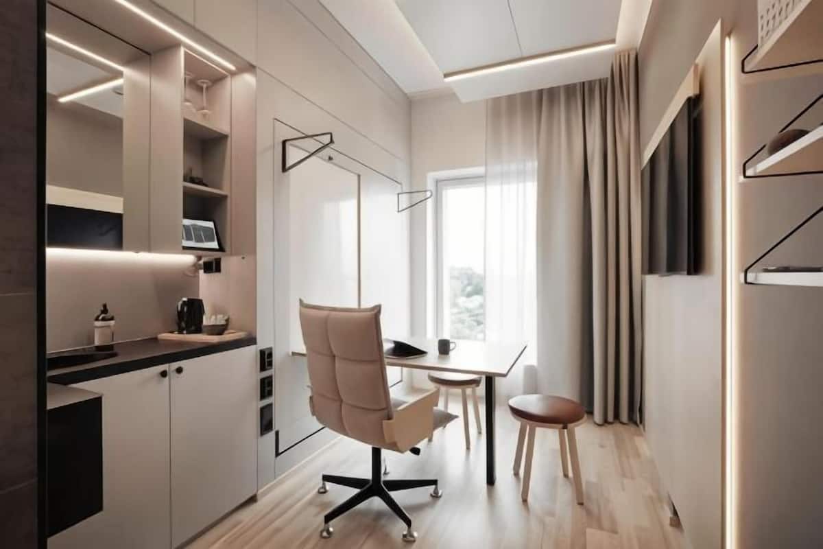 A modern kitchen with a dining area, a chair, a table, and a window with curtains.