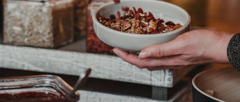 Una persona sosteniendo un tazón de granola con una cuchara.