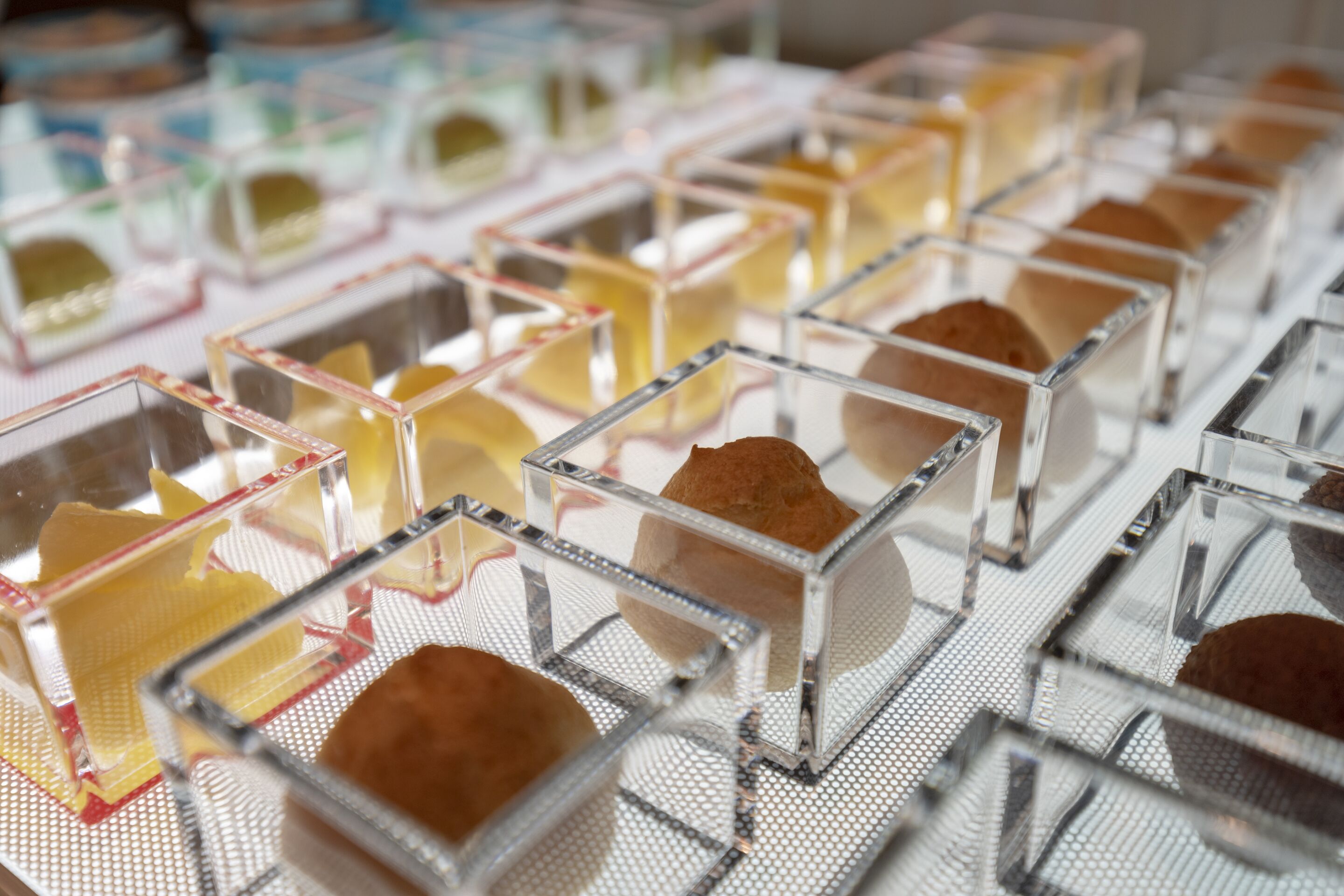A display of desserts in clear containers.