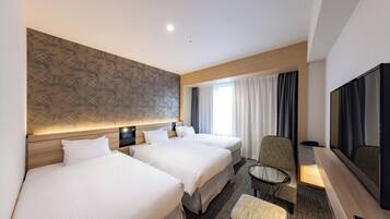A hotel room with two beds, a TV, a small table, and a chair.