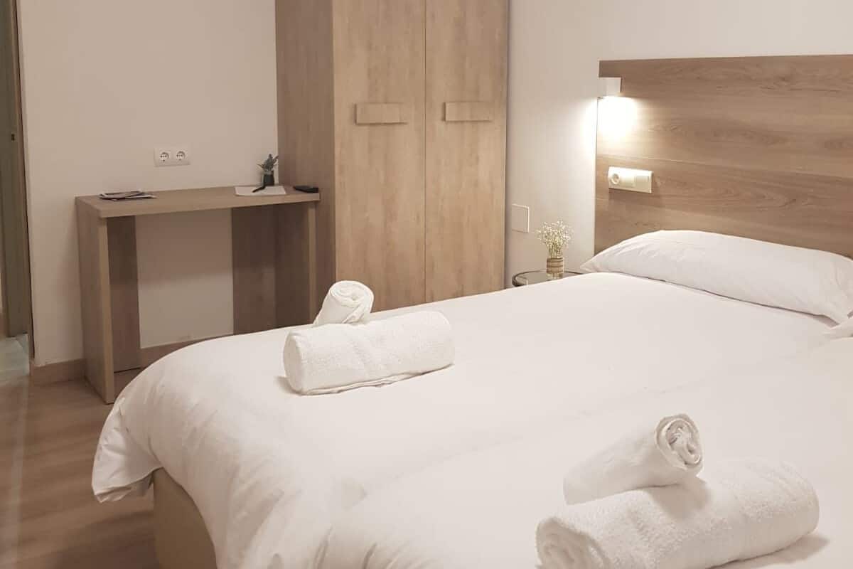 Una habitación de hotel con cama, escritorio y armario.