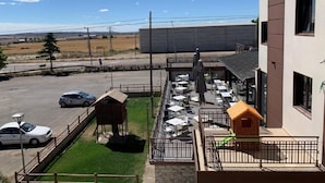 A patio area with outdoor seating, a small playhouse, and a fenced parking lot. - Hotel El Cobertizo (La Sotonera)