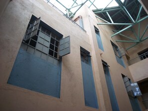 A multi-story building with a flat roof and a series of windows with metal bars. - Chartered Guest House (Ruiru)