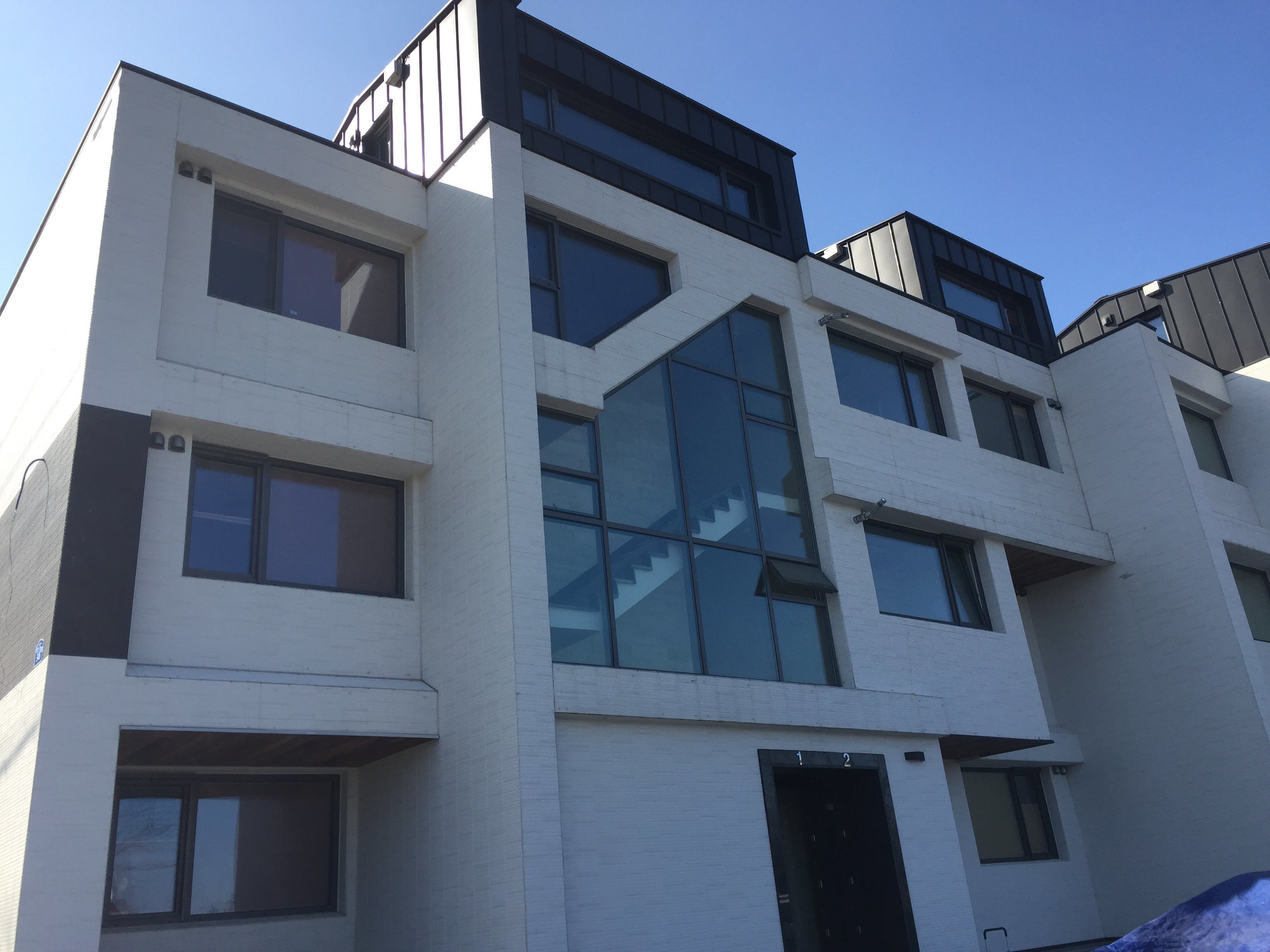A modern multi-story building with large windows and a flat roof.