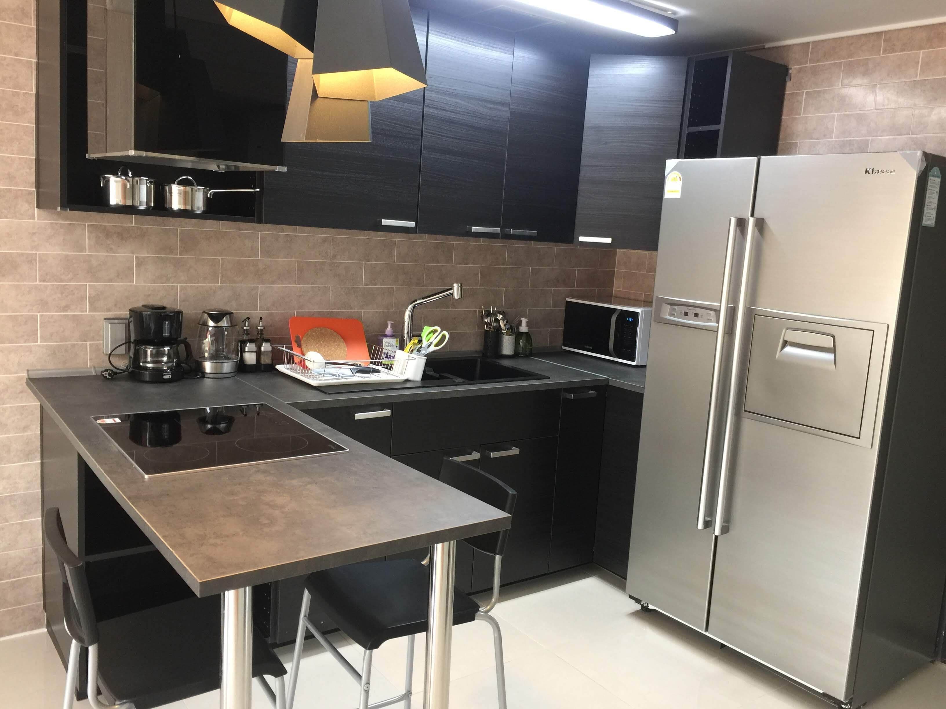 A modern kitchen with a built-in gas stove, stainless steel appliances, and a compact layout.
