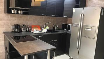 A modern kitchen with a built-in gas stove, stainless steel appliances, and a compact layout.