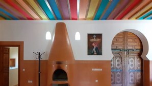 A room with a checkered floor, a fireplace, a coat rack, and a door with a decorative pattern. - Villa Familliale Jardin Piscine (Marrakech)