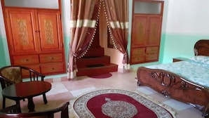 A bedroom with a bed, a chair, a table, and a wardrobe. - Villa Familliale Jardin Piscine (Marrakech)