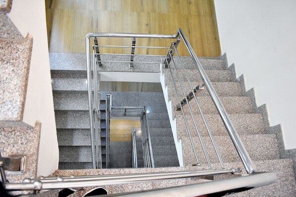 A modern staircase with metal railings and granite steps. - The Century Plaza Hotel (Varanasi)
