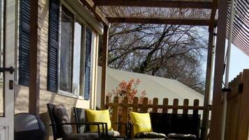 A wooden deck with outdoor furniture, including chairs and a table.