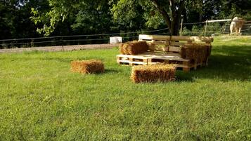 Een grasveld met hooibalen en een houten platformstructuur.