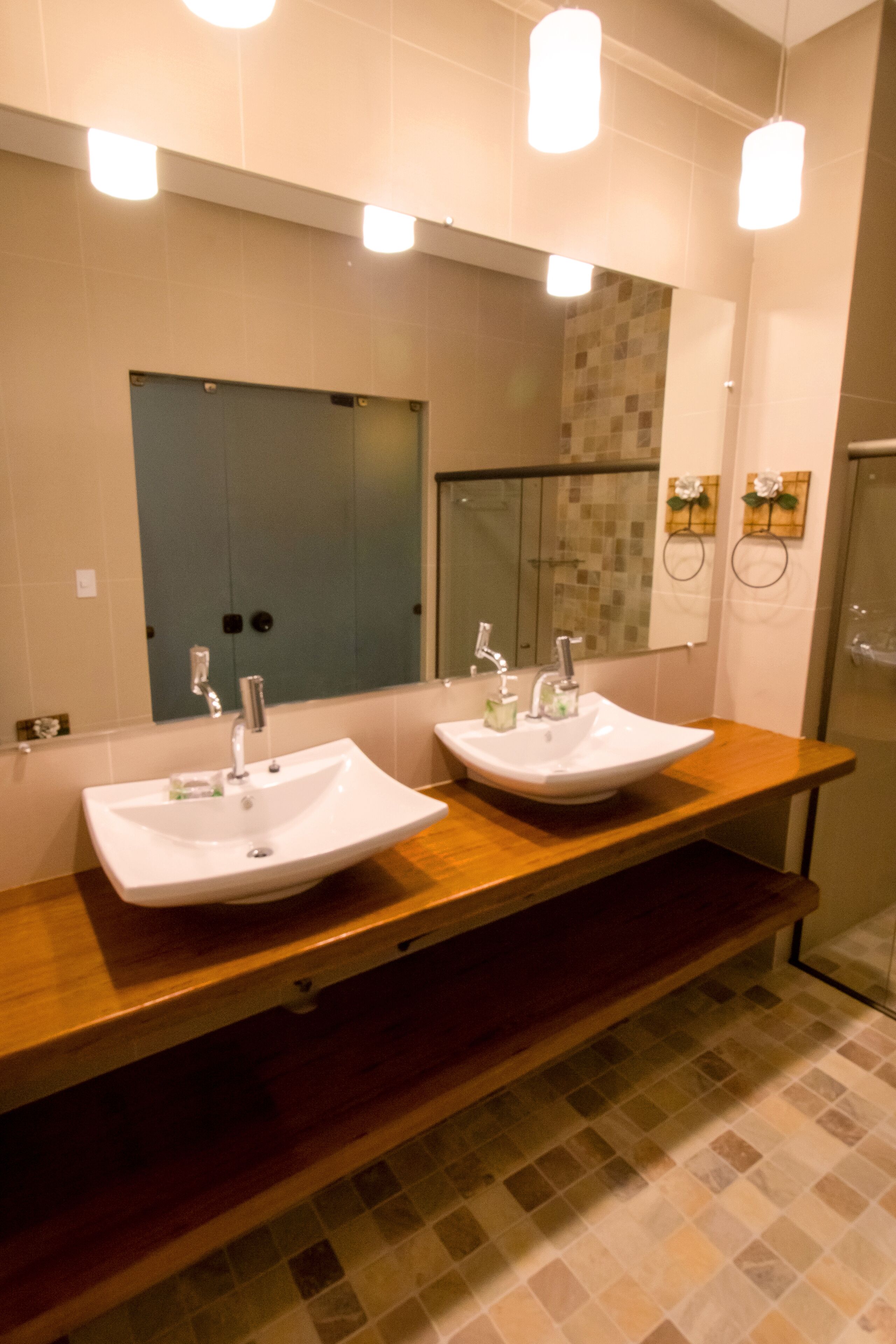 Un baño con dos lavamanos, un espejo y una ducha.