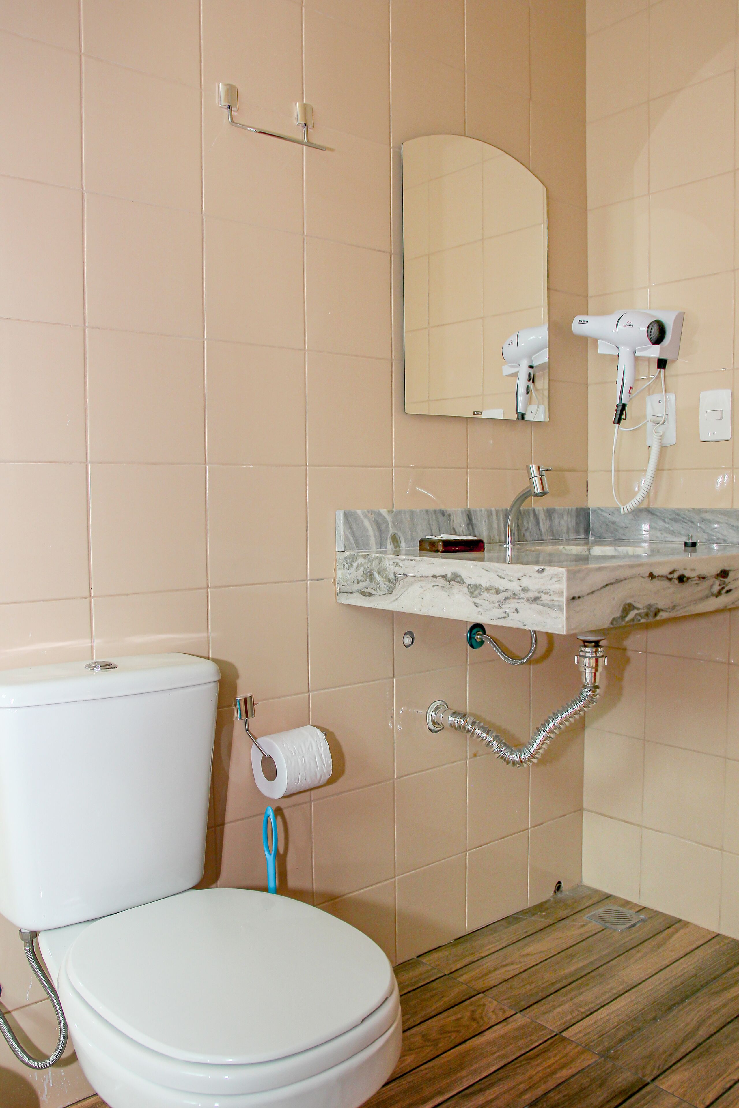 Bagno con WC, lavandino, specchio e asciugacapelli.