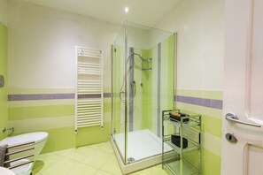 A bathroom with a glass-enclosed shower, a white toilet, and a towel rack. - Borgo Pinti Angels (Florence)